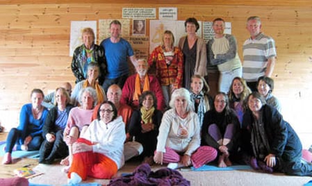 Archived photo of Muz Murray guiding an early mantra workshop circle with close student participation.